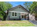 Charming craftsman-style home featuring a large front porch, green siding, and a well-maintained front yard at 905 Gaston Sw St, Atlanta, GA 30310