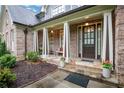 Charming covered front porch with stone flooring, brick columns, and a cozy seating area at 26 Trillium Ln, Acworth, GA 30101