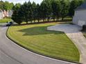 Spacious front yard featuring a well-manicured lawn and a concrete driveway leading to the garage at 3898 Heritage Oaks Dr, Powder Springs, GA 30127