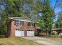 This brick home features a well-maintained lawn, a two-car garage and mature trees for added curb appeal at 2516 Cherry Hill Ln, Atlanta, GA 30360