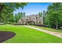 A charming brick home with a lush green lawn and well-maintained landscaping, exudes classic elegance at 771 Tate Overlook, Marietta, GA 30064