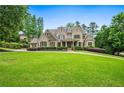 Stately brick home with a sprawling green lawn and mature trees, offering curb appeal and privacy at 771 Tate Overlook, Marietta, GA 30064