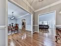 Open concept living spaces featuring hardwood floors, neutral paint, and elegant trim and dining and living spaces at 5090 Eubanks Rd, Woodstock, GA 30188