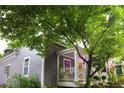 Side view of a two-story home with lilac exterior paint and lush greenery surrounding the property at 611 Pickett Se St, Atlanta, GA 30316
