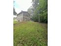 Spacious backyard with a gentle slope and lush green grass, perfect for outdoor activities at 5388 Robertson Path, Lithonia, GA 30038