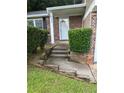 Inviting front entrance with brick accents, trimmed bushes, and a bright white front door at 5388 Robertson Path, Lithonia, GA 30038