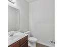 Neat half bathroom with a dark wood vanity and white fixtures at 1099 Sandy Bank Ct, Auburn, GA 30011