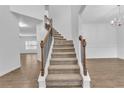 Elegant staircase with wood railing and carpeted steps, leading to the upper level of the home at 1099 Sandy Bank Ct, Auburn, GA 30011