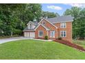 Charming brick two-story home with a two-car garage and a playset on the lawn at 1784 Brookstone Nw Ct, Acworth, GA 30101