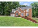 Charming brick two-story home with a two-car garage and a playset on the lawn at 1784 Brookstone Nw Ct, Acworth, GA 30101
