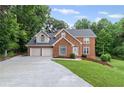 Charming brick two-story home with a two-car garage and a well-maintained lawn at 1784 Brookstone Nw Ct, Acworth, GA 30101