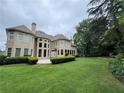Expansive backyard with a lush lawn and well-maintained landscaping surrounding a tan two-story home at 2503 Regency Lake Dr, Marietta, GA 30062