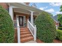 Welcoming front porch with brick steps, white railing, and manicured bushes at 793 Fairington Pl, Lawrenceville, GA 30044