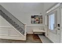Light-filled foyer with hardwood floors, a staircase with iron railings, and an elegant bench at 3355 Olivia Ct, Cumming, GA 30041