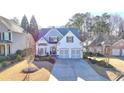Inviting two-story home with a manicured lawn, attached two-car garage, and a welcoming entrance at 3355 Olivia Ct, Cumming, GA 30041