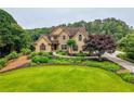 Charming two-story home featuring a well-manicured lawn, lush landscaping, and a winding walkway at 2675 Portabella Ln, Cumming, GA 30041