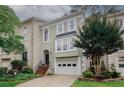 Lovely townhome with a two-car garage, a well-manicured lawn, and a charming entrance with a garden at 3697 E Bay St, Duluth, GA 30096