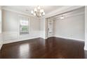 Elegant dining room with dark hardwood floors, white wainscoting, and a chandelier at 4090 Danbury Farms Dr, Cumming, GA 30040