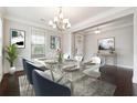 Well-lit dining room with chandelier, wainscoting, and ample natural light at 4090 Danbury Farms Dr, Cumming, GA 30040