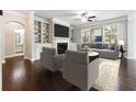 Bright living room features built-in shelving, fireplace, ceiling fan and hardwood floors at 4090 Danbury Farms Dr, Cumming, GA 30040