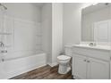 Clean, well-lit bathroom featuring a bathtub with shower and a modern vanity at 2182 Talmai Dr, Snellville, GA 30078