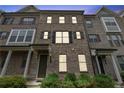 Traditional brick townhome featuring multi-pane windows, dark shutters, and covered entryways at 2182 Talmai Dr, Snellville, GA 30078