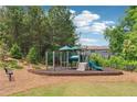 Outdoor playground with slide, climbing bars, and benches surrounded by mature trees at 2182 Talmai Dr, Snellville, GA 30078