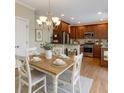 Charming dining area offers a modern chandelier and warm wood-finished kitchen at 3641 Ridge Towne Dr, Duluth, GA 30096