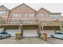 Rear exterior shot featuring garages and balconies, offering outdoor living space at 4358 Grove Field Ct, Suwanee, GA 30024