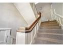 Carpeted staircase with wooden banister and white trim at 1156 Piedmont Ne Ave # B3, Atlanta, GA 30309