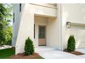 Welcoming front entrance with a light-stained door, modern lighting, and trimmed greenery, with light-colored brick at 2745 S Bamby Ne Ln, Brookhaven, GA 30319