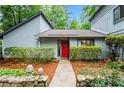 Inviting home entrance with a bright red door, stone details, and a walkway framed by manicured greenery at 895 Fawn Way, Marietta, GA 30068