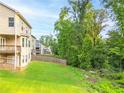 A beautiful home featuring a large yard, lush trees and landscaping in the backyard at 1838 Lakeview Bend Way, Buford, GA 30519