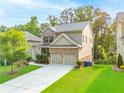 Charming two-story home featuring a brick facade, manicured lawn, and a two-car garage at 1838 Lakeview Bend Way, Buford, GA 30519