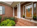 Charming brick front porch adorned with flowers and a decorative wood door at 223 Oak Grove Dr, Dallas, GA 30157