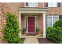 Inviting front entrance with a burgundy door, potted plants, and white trim at 3032 Montclair Se Cir, Smyrna, GA 30080