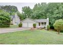 Charming single-story home with a two-car garage, front porch, green yard and wooded lot at 3960 Rocmar Dr, Snellville, GA 30039