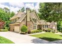 Expansive home featuring attached garage, well-maintained lawn, and lush surrounding greenery at 702 Crescent Cir, Canton, GA 30115