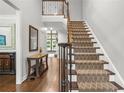 Staircase and hardwood flooring in an open foyer space with stylish console table and decor at 702 Crescent Cir, Canton, GA 30115
