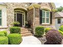 Inviting front entrance featuring brick steps, decorative plants, and elegant door design at 702 Crescent Cir, Canton, GA 30115