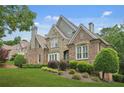 Exterior home view showcases a well-maintained lawn and lush greenery at 702 Crescent Cir, Canton, GA 30115