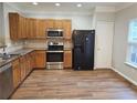 Kitchen featuring wood cabinets, stainless appliances, and wood flooring at 2137 Meadow Peak Rd, Duluth, GA 30097