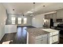 Open-concept living area with hardwood floors, modern lighting, and abundant natural light at 3677 Hidden Valley Cir, Lawrenceville, GA 30044