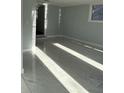 A bright basement with gray walls and large tile flooring leading to another area at 6774 Collier Rd, Riverdale, GA 30296
