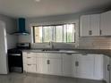 Updated kitchen featuring white cabinets, subway tile, and stainless steel appliances at 6774 Collier Rd, Riverdale, GA 30296