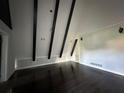 Open living room with dark wood floors, beamed ceilings, and modern trim at 6774 Collier Rd, Riverdale, GA 30296