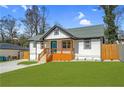 Beautifully renovated home with a modern exterior, inviting porch and manicured lawn at 3470 Glenwood Rd, Decatur, GA 30032
