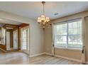 Bright dining room featuring wood-look floors, contemporary light fixture and many windows at 6684 Crane Ave, Fairburn, GA 30213