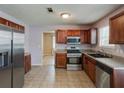 Spacious kitchen boasts stainless steel appliances, wood cabinetry, and tile floors at 6684 Crane Ave, Fairburn, GA 30213
