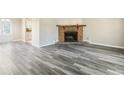 Bright living room featuring a cozy fireplace and modern gray wood flooring at 5422 Timor Trl, Lithonia, GA 30038